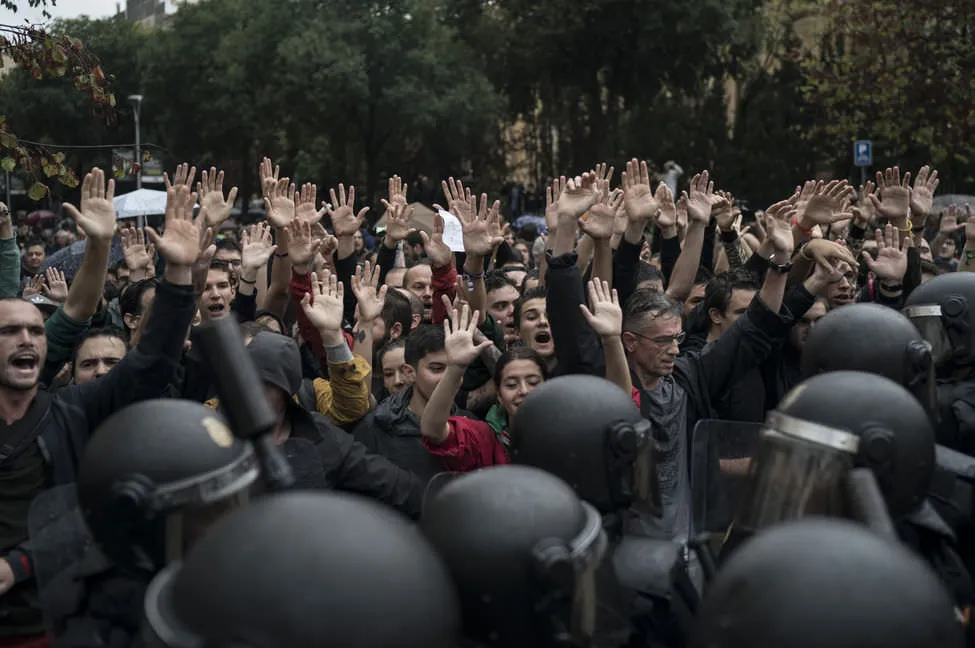 People with raised hands, before riot officers in front of a school in Barcelona (Felipe Dana / AP Photo) People with raised hands, before riot officers in front of a school in Barcelona (Felipe Dana / AP Photo)